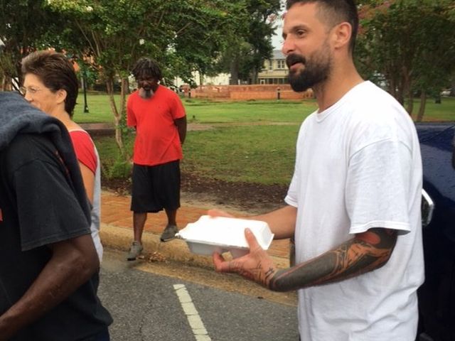 A man receives a meal at an outreach